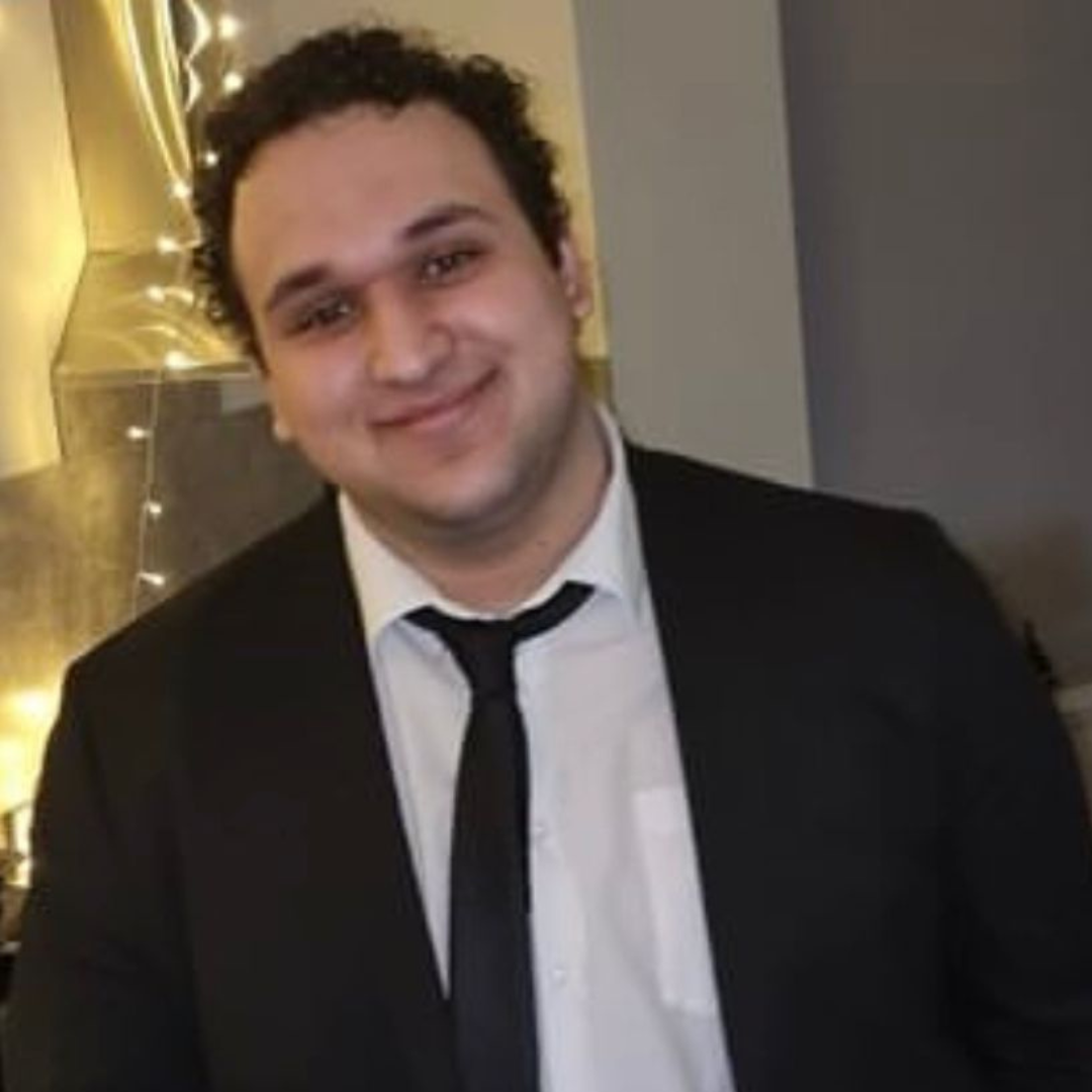 Man with dark hair wearing shirt and tie