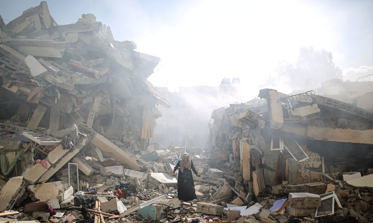 A resident gets upset as she walks amid near the rubble of residential buildings after Israeli airstrikes at al-Zahra neighborhood in Gaza Strip on October 19, 2023.