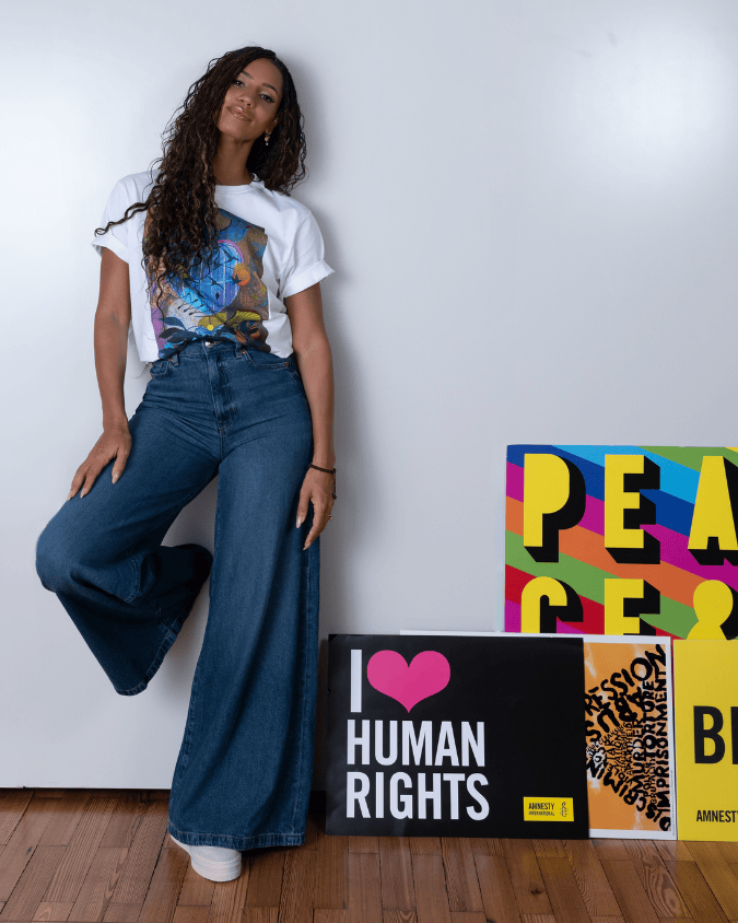 Vick Hope standing next to Amnesty posters and one says "I love human rights"  