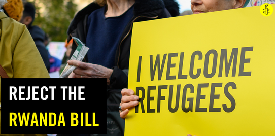 A person holds a placard which says "I welcome refugees". Text on the image says, "Reject the Rwanda Bill"