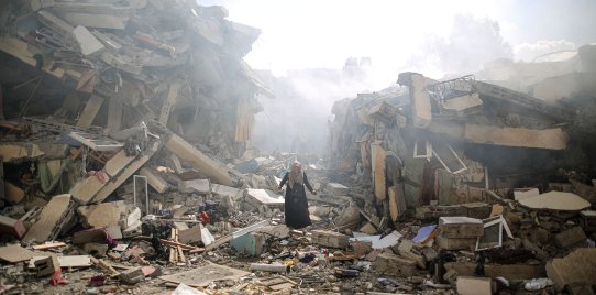 GAZA CITY, GAZA - OCTOBER 19: A resident gets upset as she walks amid near the rubble of residential buildings after Israeli airstrikes at al-Zahra neighborhood in Gaza Strip on October 19, 2023.