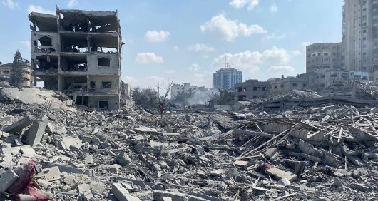 Damage of Israeli airstrikes in Gaza, with the rubble of several buildings covering the ground