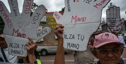 A group of people in need of treatment show their boards demanding Access to health care and medicines at the protest 