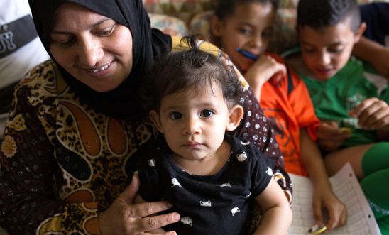 A smiling woman with her three children