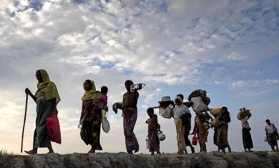 Rohingya refugees walk through a paddy field in Bangladesh in November 2017, after fleeing genocide in Myanmar’s Rakhine state