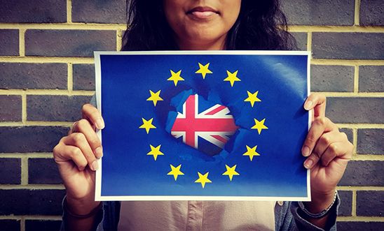 Young person holds up EU and Union Jack flag