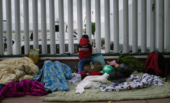 Billboard and migrant caravan in Tijuana