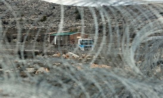 A prefabricated house is transported by a lorry after being are removed from the Israeli Amona wildcat outpost, northeast of Ramallah, in the occupied West Bank