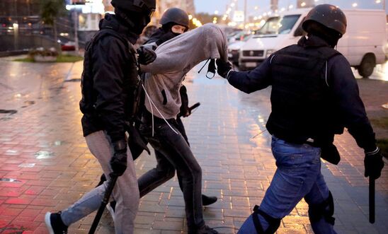 Three armed police detain an unarmed, peaceful protester in Belarus