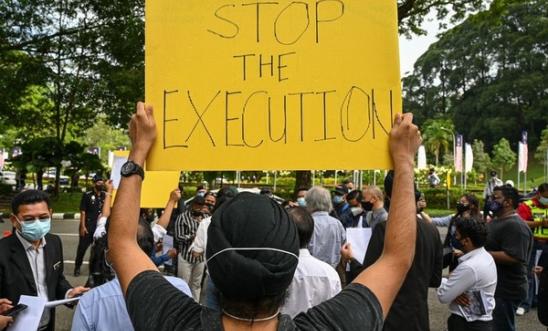 An activist holds a placard before submitting a memorandum to parliament in protest at the impending execution of Nagaenthran K. Dharmalingam