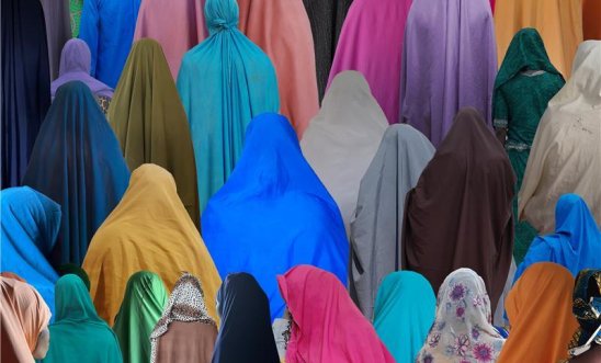 Women are seen from behind wearing traditional, loose Islamic dress in a variety of colours