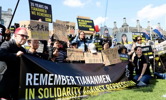 A number of protestors holding remembrance signs for 35 years since the Tiananmen square massacre.