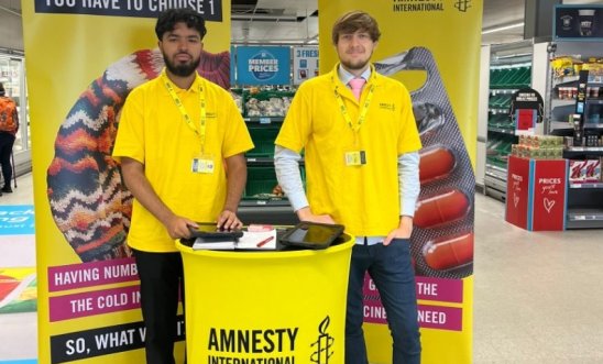 Amnesty fundraisers standing at a fundraising station in a supermarket