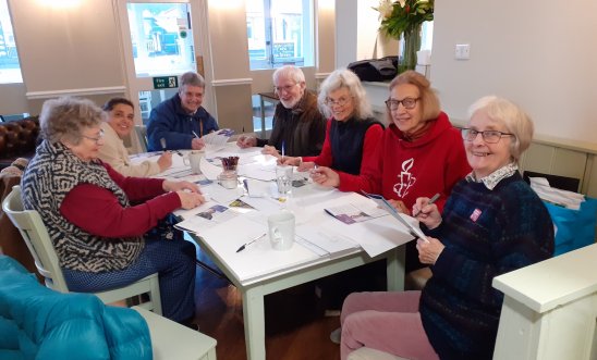 People writing letters at a table