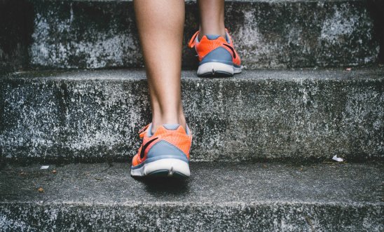 Image shows a closeup of someone walking upstairs in trainers