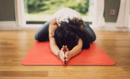 Image shows a person stretching on an exercise mat