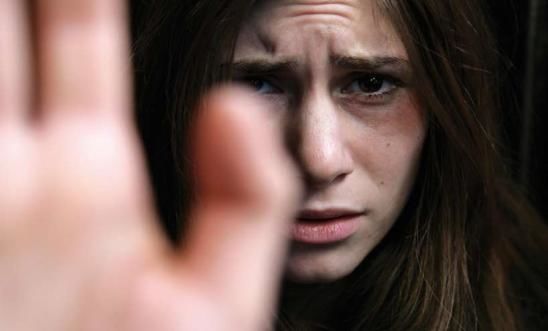 A woman holds her hand up to the camera